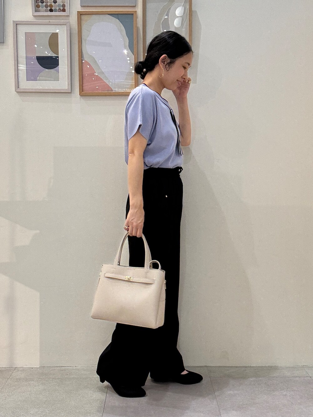 ブルー系のニット/セーター、ブラック系のその他パンツ、ベージュ系のトートバッグを着用したレディースの春コーディネートの2枚目の写真