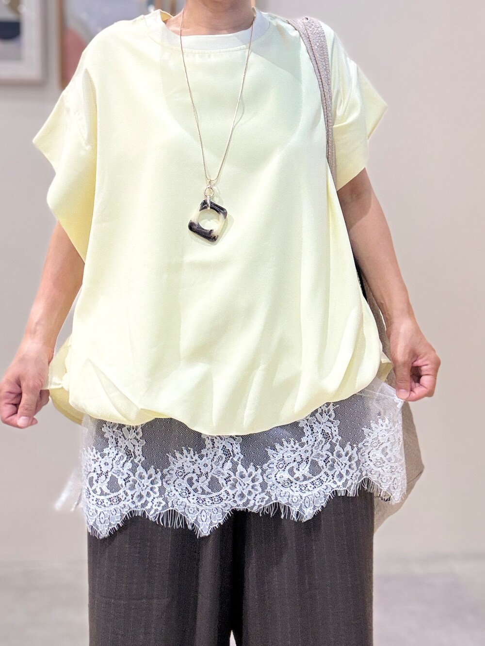 イエロー系のTシャツ/カットソー、ホワイト系のタンクトップ、ベージュ系のトートバッグを着用したレディースの夏コーディネートの4枚目の写真
