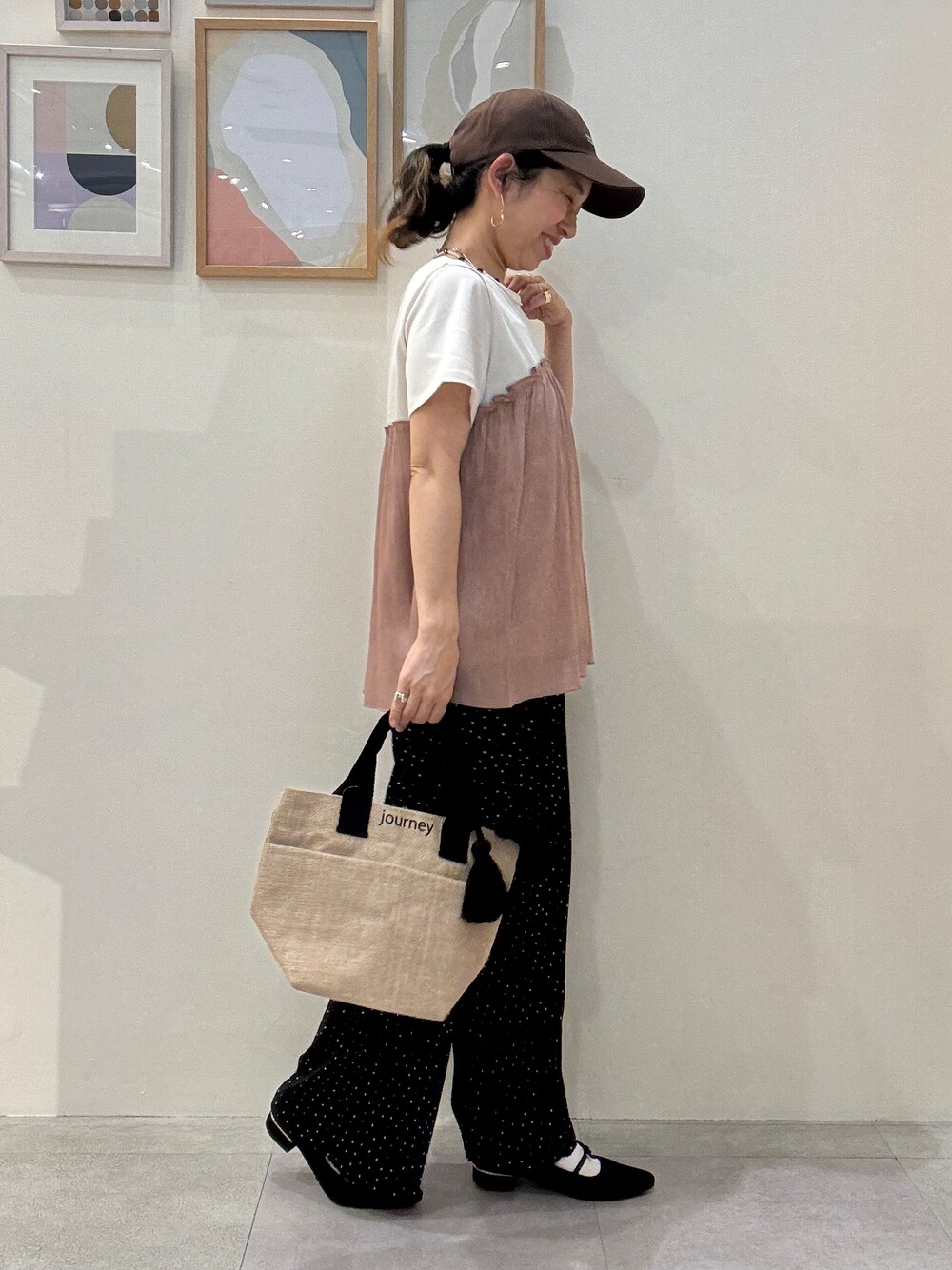 ブラック系のトートバッグ、オレンジ系のTシャツ/カットソー、ブラック系のその他パンツを着用したレディースの春コーディネートの2枚目の写真