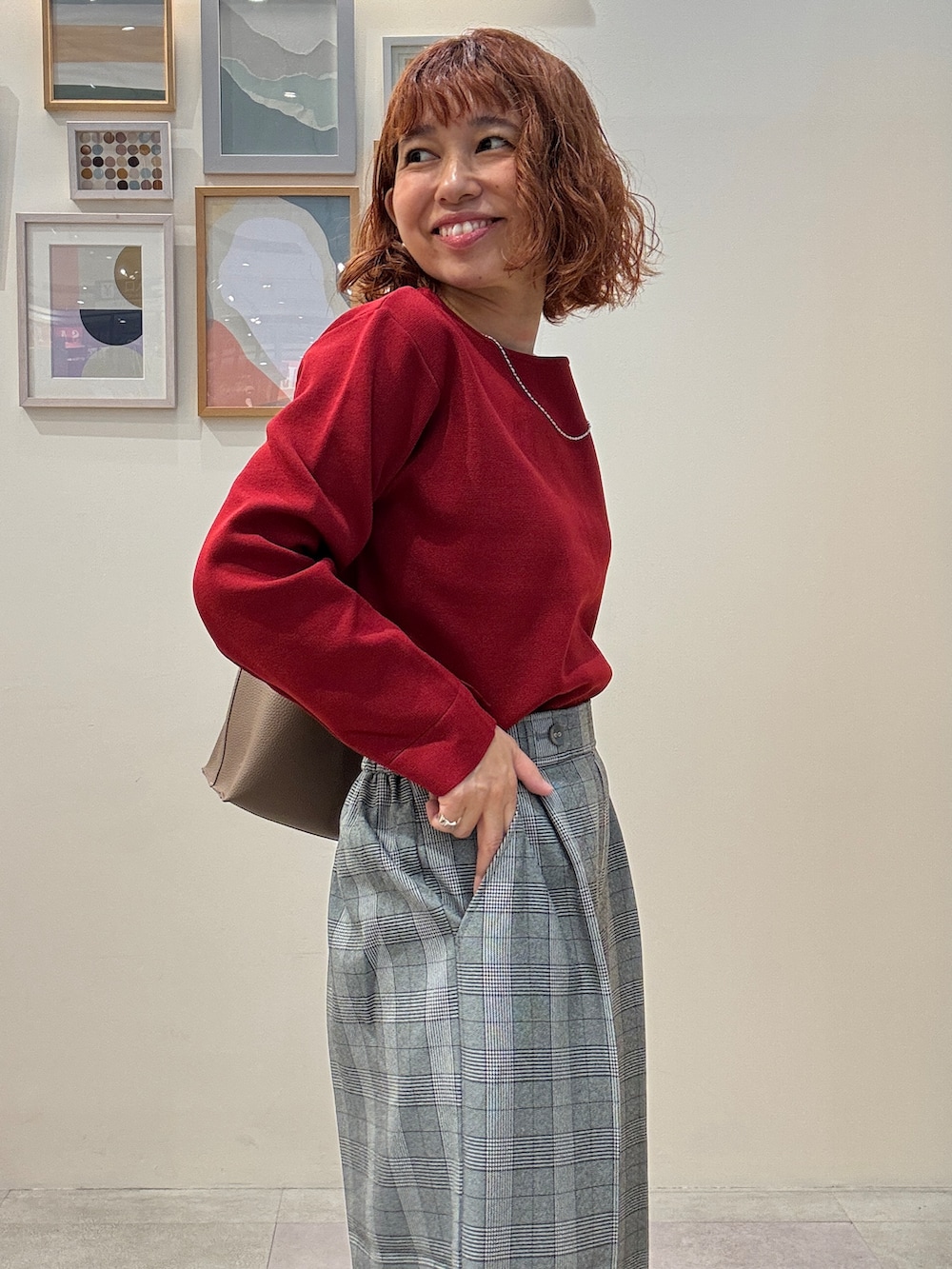 レッド系のニット/セーター、グレー系のその他パンツ、ブラック系のその他シューズを着用したレディースの秋コーディネートの4枚目の写真