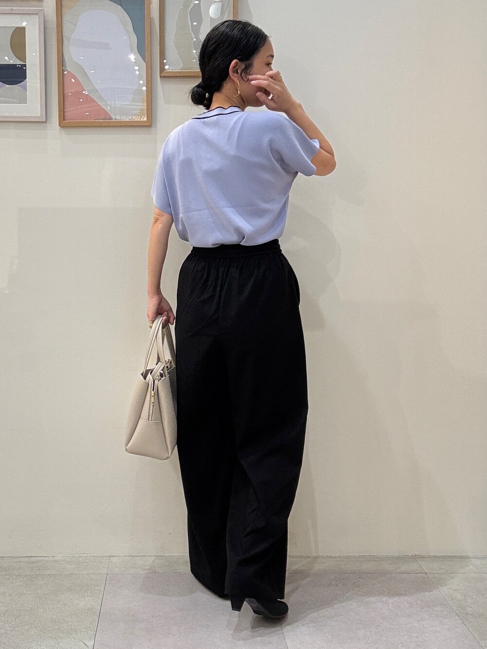 ブルー系のニット/セーター、ブラック系のその他パンツ、ベージュ系のトートバッグを着用したレディースの春コーディネートの3枚目の写真