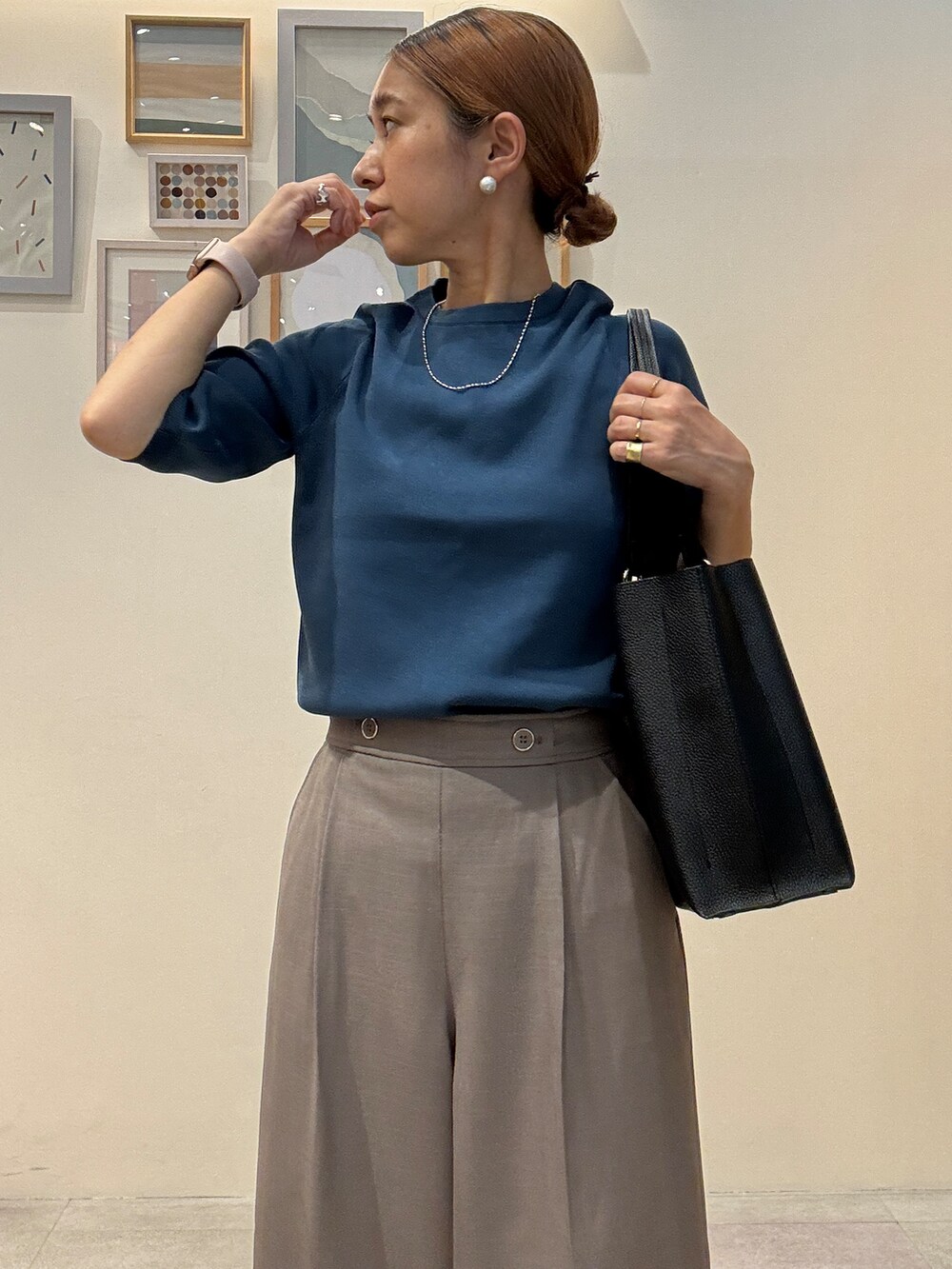 ブルー系のニット/セーター、ブラウン系のその他パンツ、ブラック系のトートバッグを着用したレディースの夏コーディネートの4枚目の写真