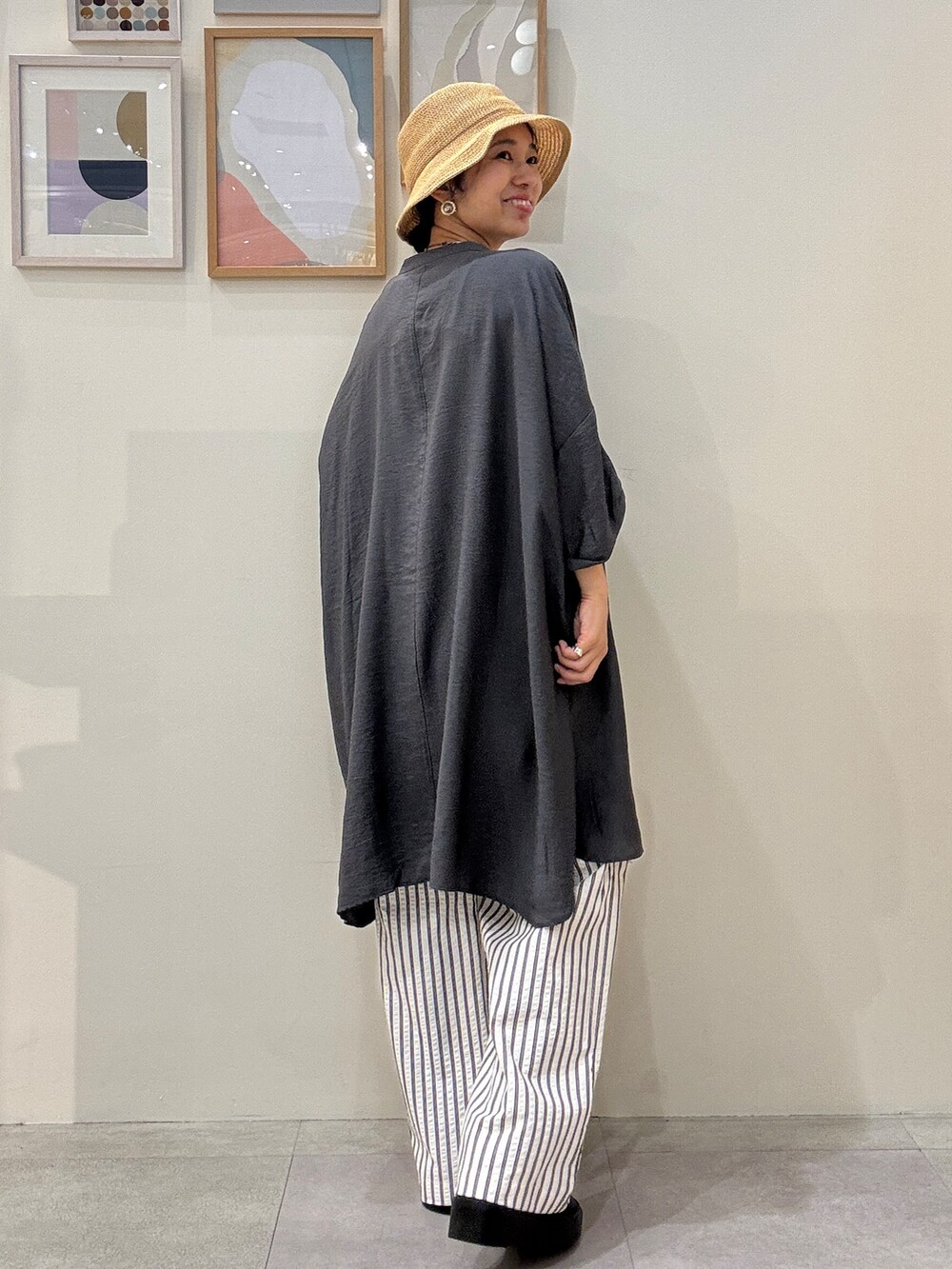 グレー系のチュニック、ベージュ系のその他パンツ、ホワイト系のトートバッグを着用したレディースの春コーディネートの3枚目の写真