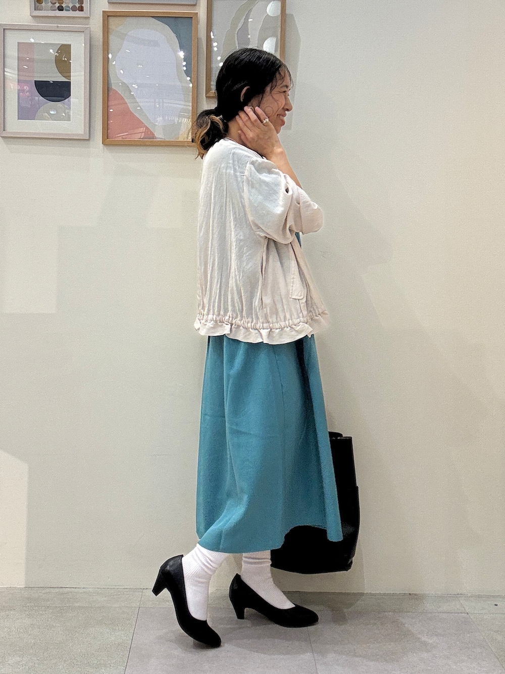 ベージュ系のブルゾン、ブルー系のワンピース、ブラック系のトートバッグを着用したレディースの夏コーディネートの2枚目の写真