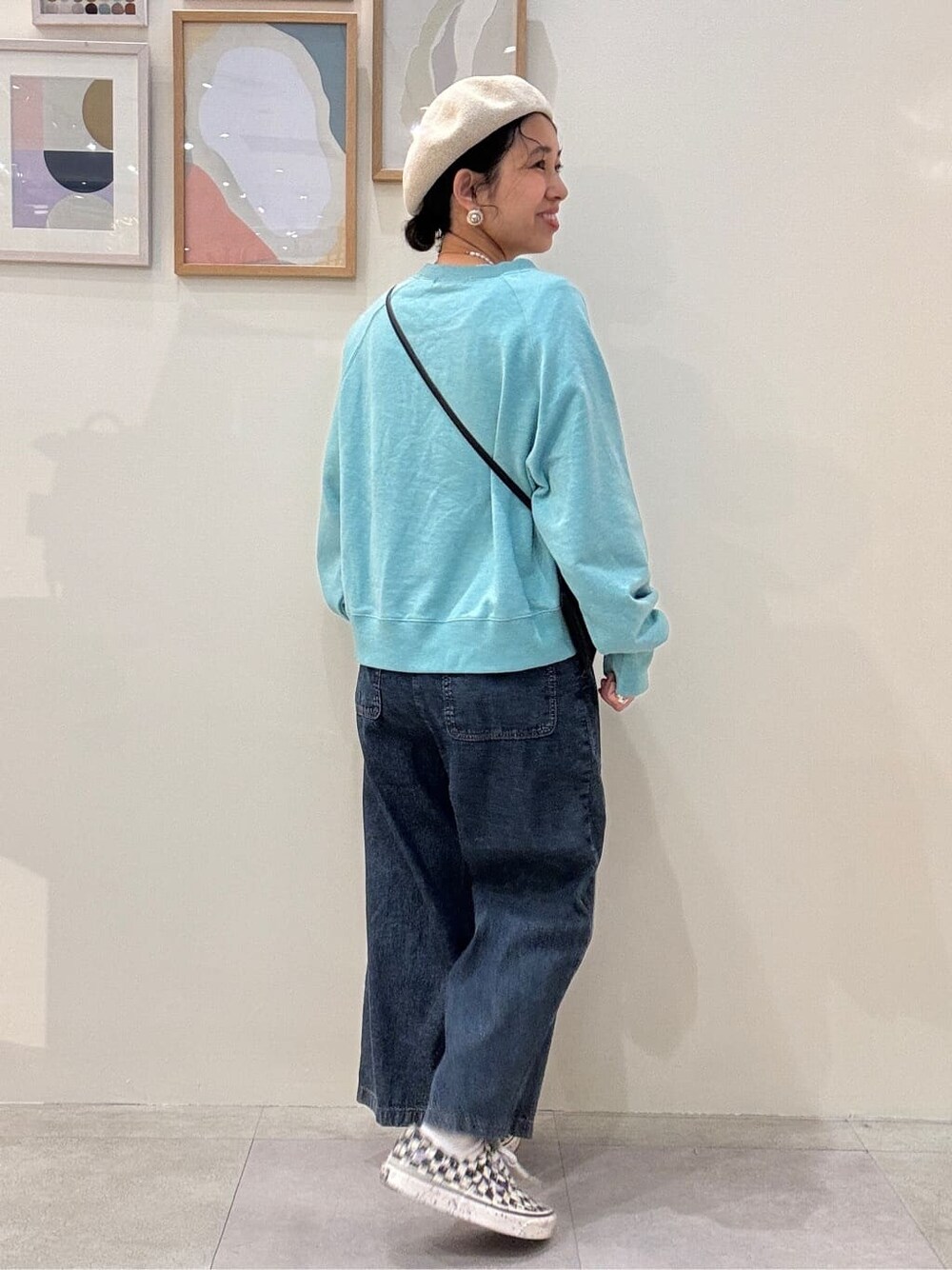 ブルー系のスウェット、ブルー系のデニムパンツ、ベージュ系のハンチング/ベレー帽を着用したレディースの春コーディネートの3枚目の写真