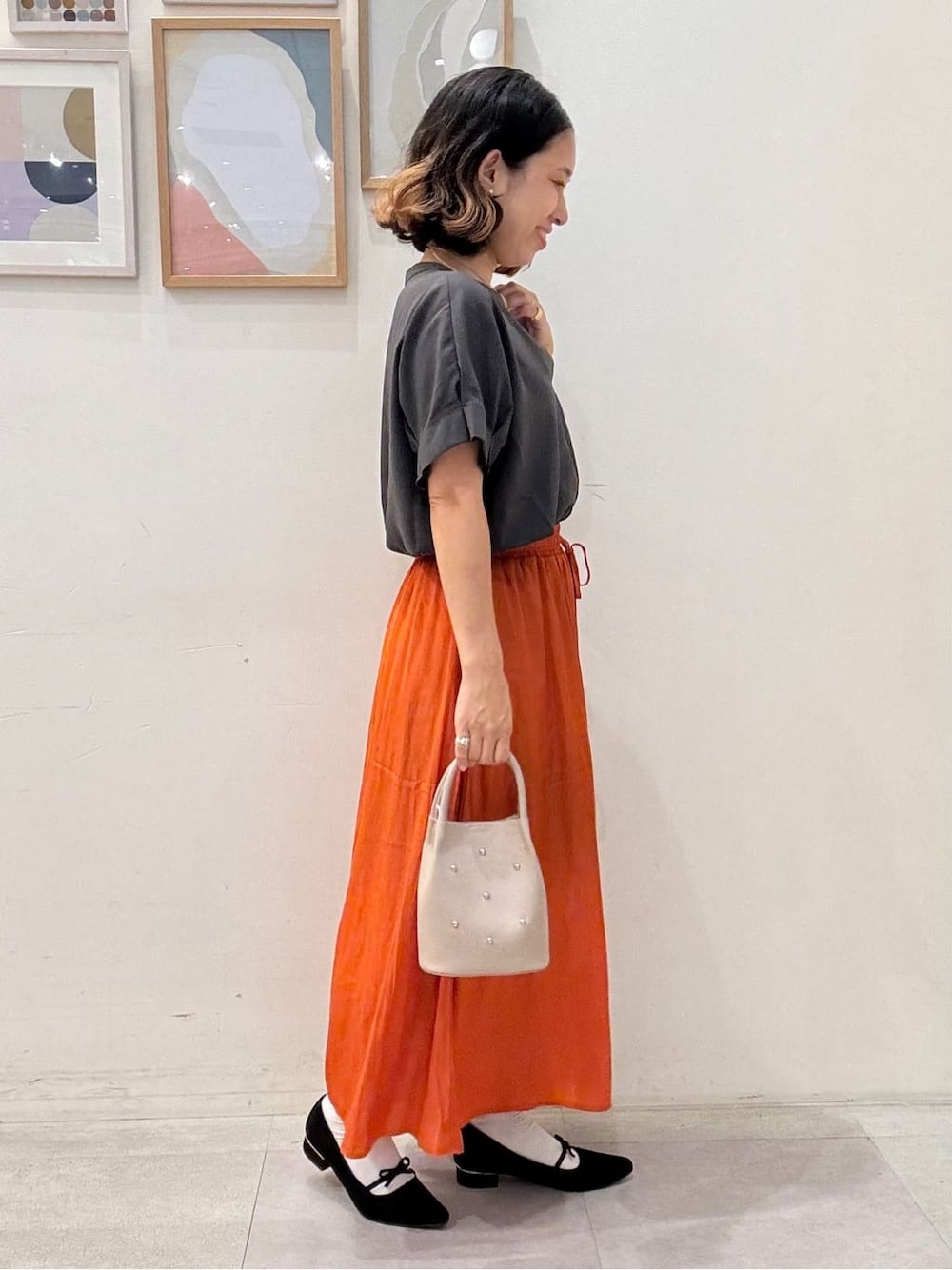 グレー系のシャツ/ブラウス、オレンジ系のその他パンツ、ベージュ系のショルダーバッグを着用したレディースの夏コーディネートの2枚目の写真