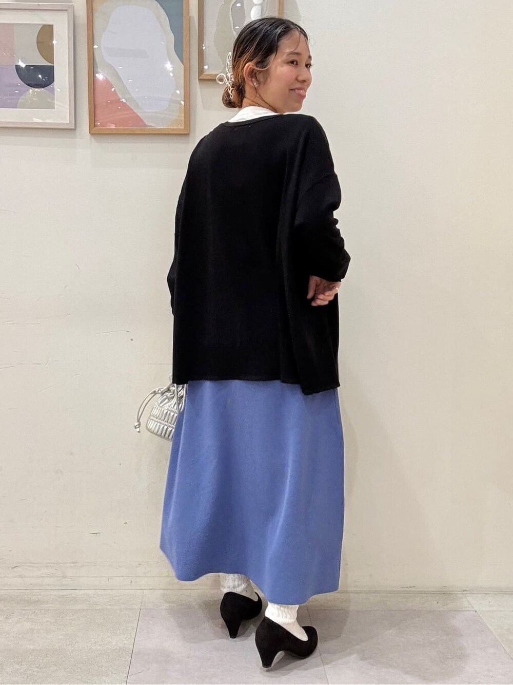ブラック系のカーディガン/ボレロ、ホワイト系のTシャツ/カットソー、ブルー系のスカートを着用したレディースの春コーディネートの3枚目の写真
