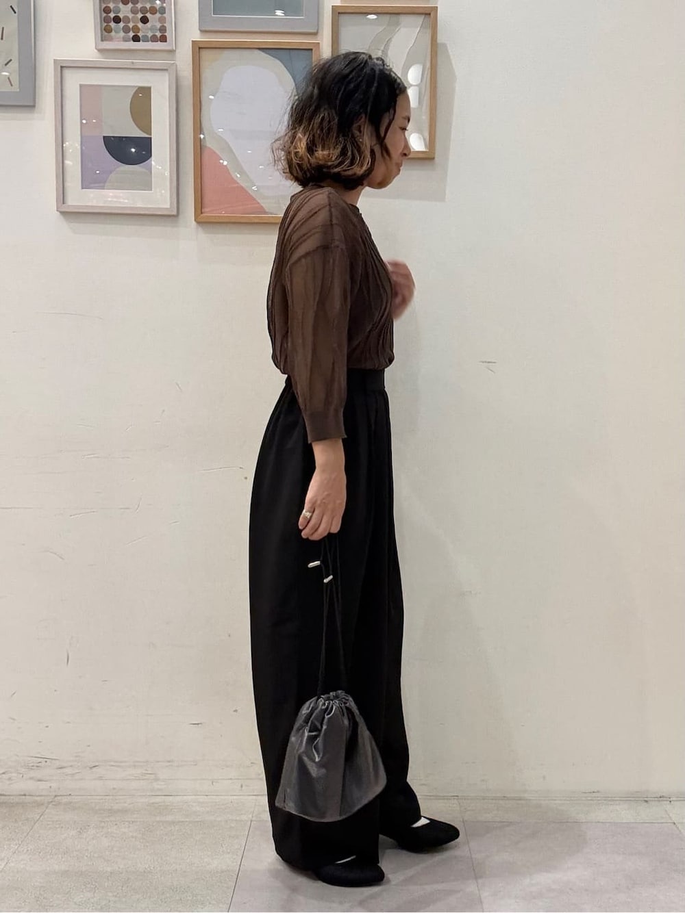 ブラウン系のニット/セーター、ブラック系のその他パンツ、グレー系のショルダーバッグを着用したレディースの秋コーディネートの2枚目の写真
