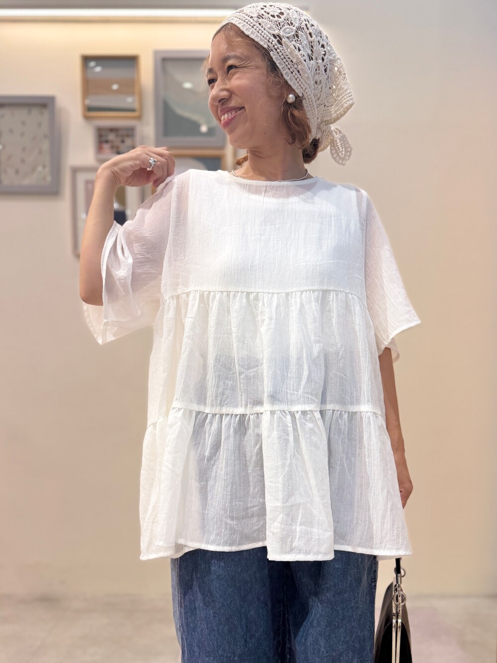 ブルー系のデニムパンツ、ブラック系のサンダルを着用したレディースの夏コーディネートの4枚目の写真