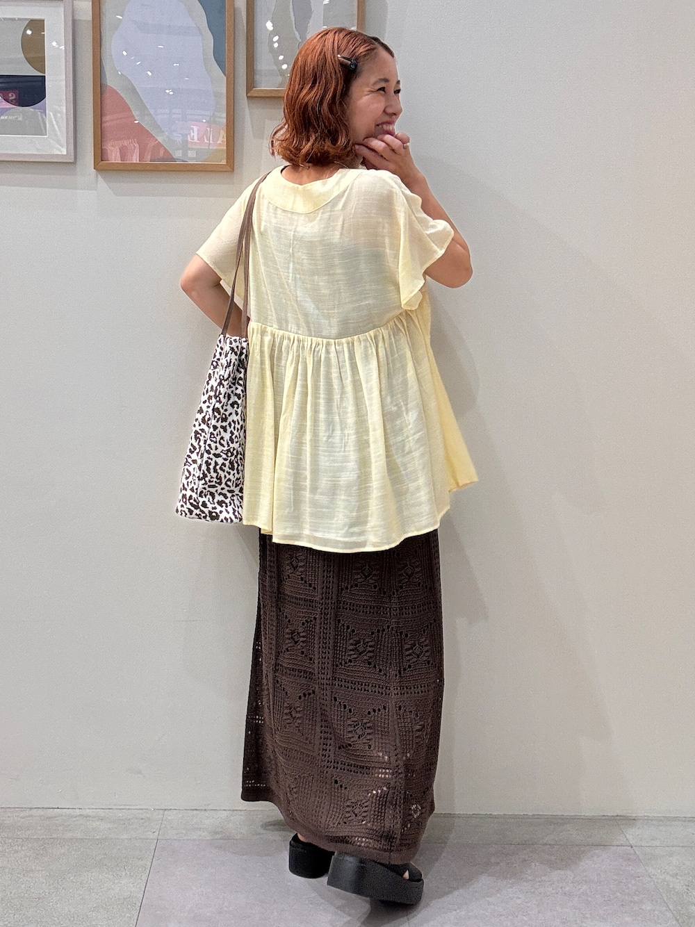 イエロー系のシャツ/ブラウス、ブラウン系のスカート、ブラック系のサンダルを着用したレディースの夏コーディネートの3枚目の写真