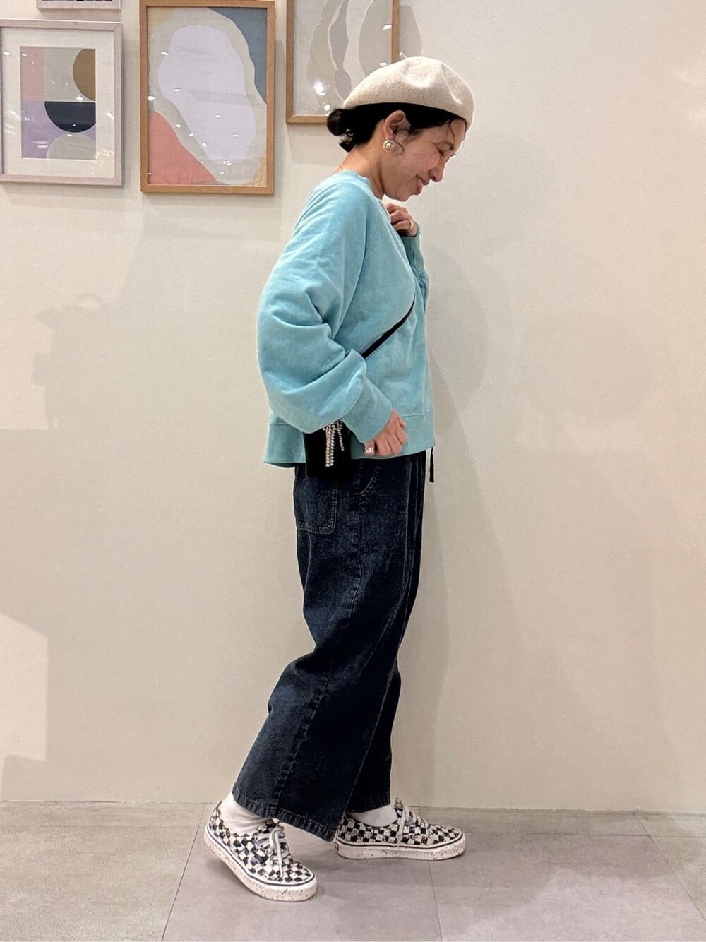 ブルー系のスウェット、ブルー系のデニムパンツ、ベージュ系のハンチング/ベレー帽を着用したレディースの春コーディネートの2枚目の写真