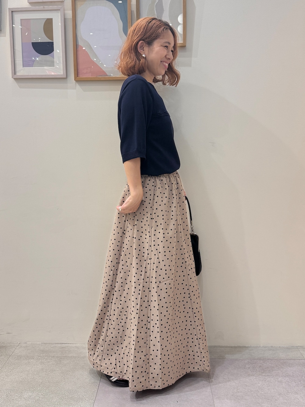 ブルー系のニット/セーター、ブラウン系のスカート、ブラウン系のサンダルを着用したレディースの夏コーディネートの2枚目の写真