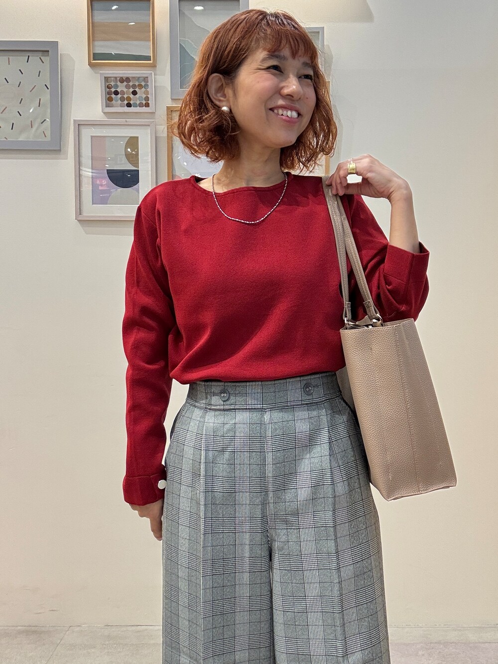 レッド系のニット/セーター、グレー系のその他パンツ、ブラック系のその他シューズを着用したレディースの秋コーディネートの5枚目の写真