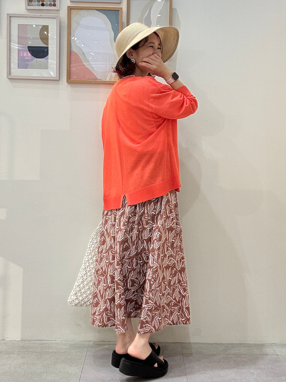 オレンジ系のカーディガン/ボレロ、ホワイト系のTシャツ/カットソー、レッド系のスカートを着用したレディースの夏コーディネートの3枚目の写真