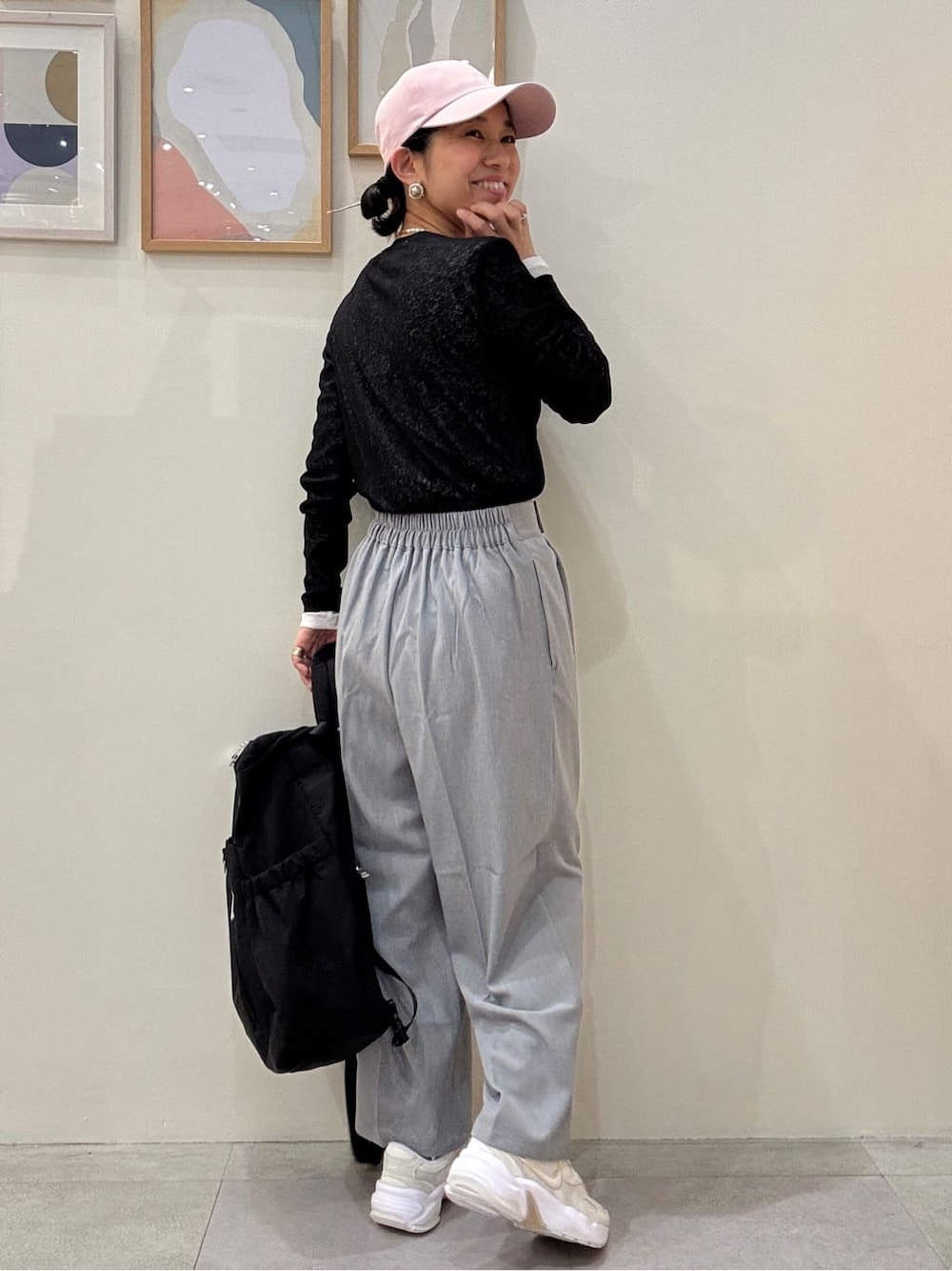 グレー系のその他パンツ、ブラック系のバックパック/リュック、ピンク系のキャップを着用したレディースの春コーディネートの3枚目の写真