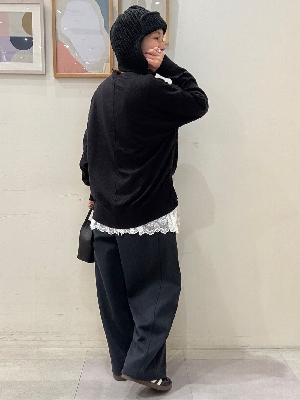 ブラック系のニット/セーター、ホワイト系のTシャツ/カットソー、ブラック系のその他パンツを着用したレディースの秋コーディネートの3枚目の写真