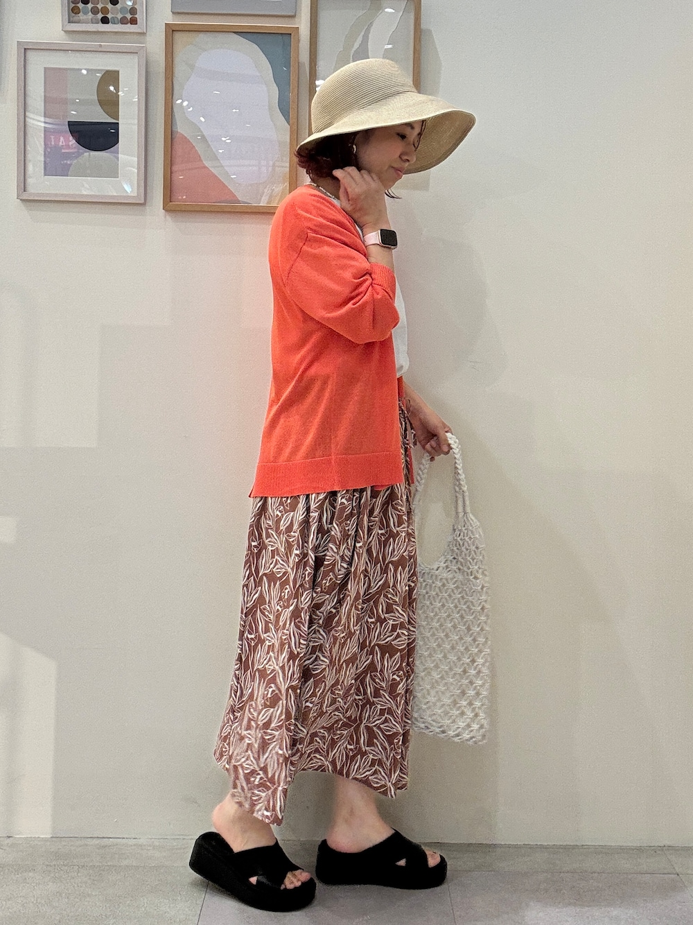 オレンジ系のカーディガン/ボレロ、ホワイト系のTシャツ/カットソー、レッド系のスカートを着用したレディースの夏コーディネートの2枚目の写真