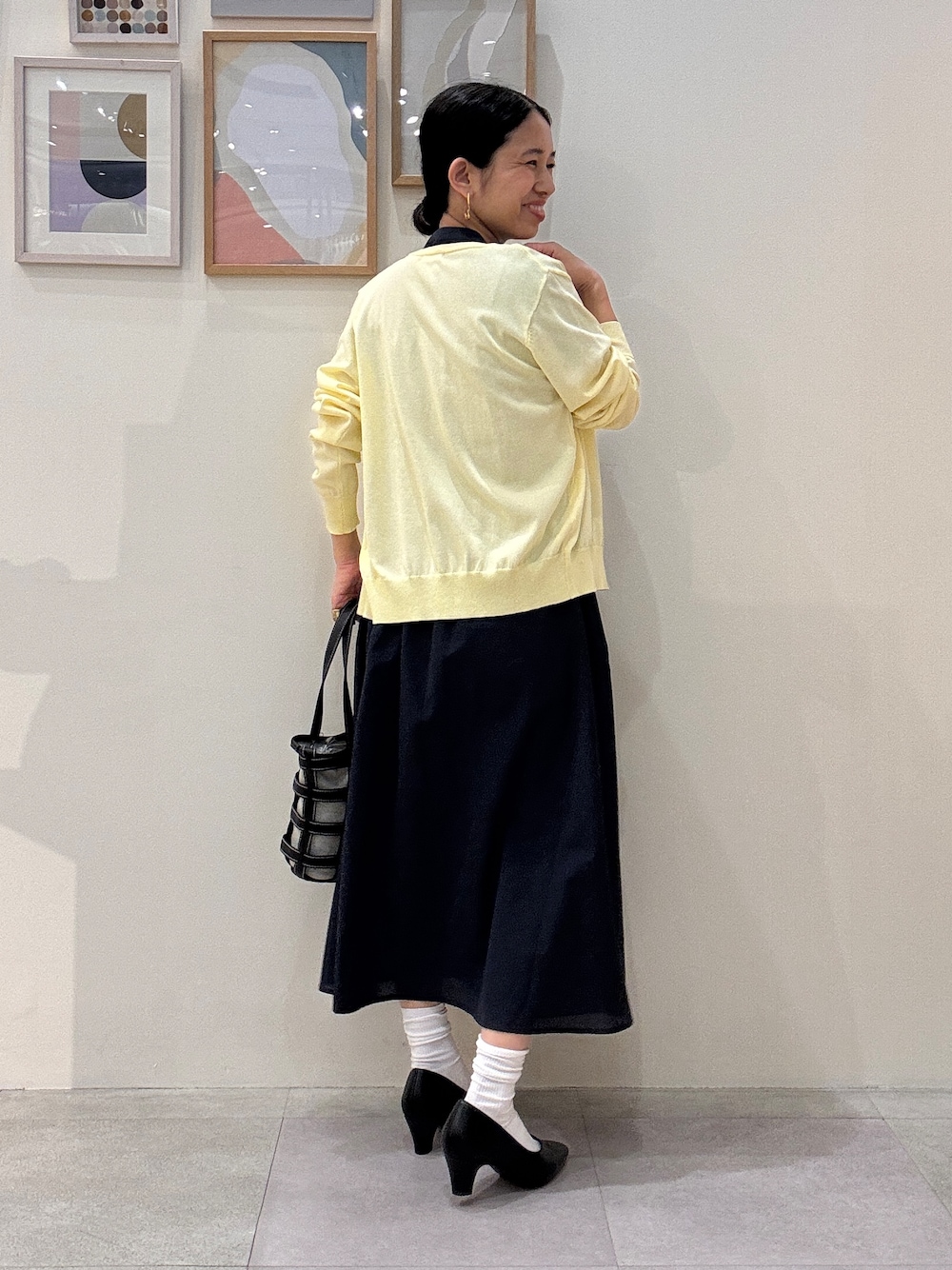 イエロー系のカーディガン/ボレロ、ブルー系のワンピース、ブラック系のトートバッグを着用したレディースの夏コーディネートの3枚目の写真