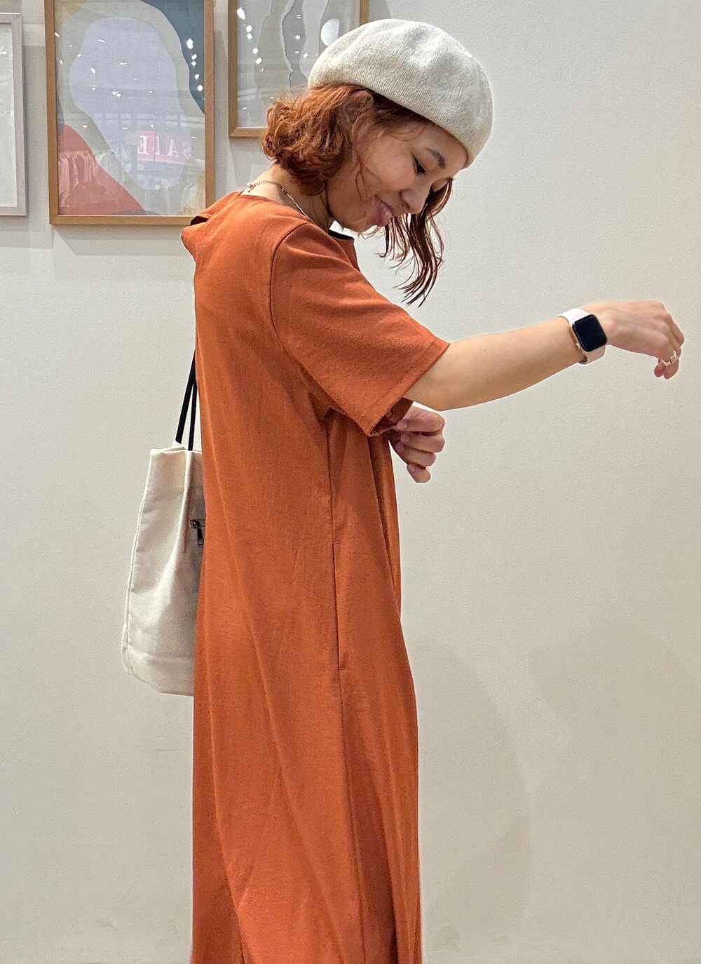 オレンジ系のワンピース、ホワイト系のトートバッグ、ブラック系のサンダルを着用したレディースの夏コーディネートの6枚目の写真