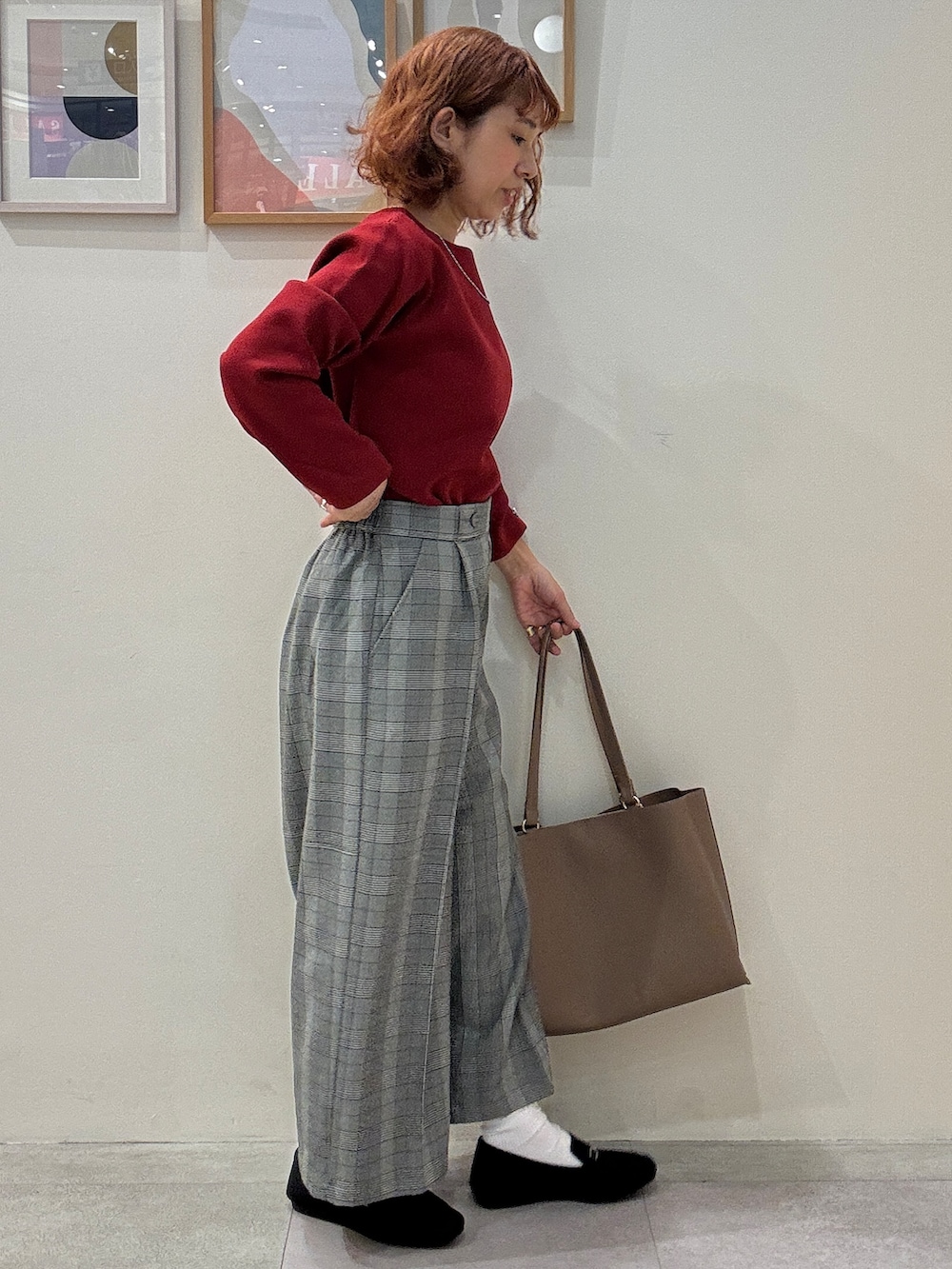 レッド系のニット/セーター、グレー系のその他パンツ、ブラック系のその他シューズを着用したレディースの秋コーディネートの2枚目の写真