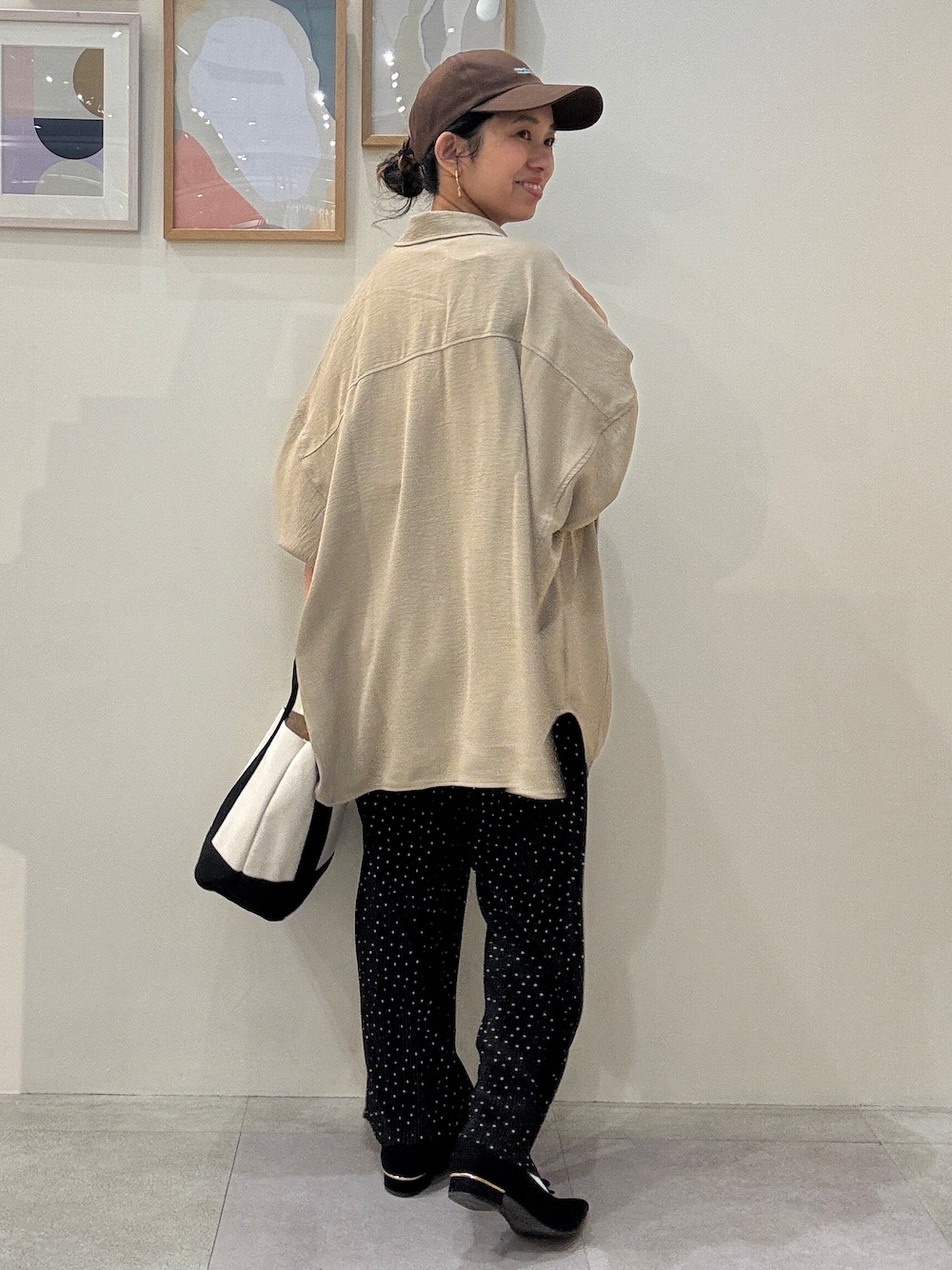 ブラック系のトートバッグ、ベージュ系のシャツ/ブラウス、ブラック系のその他パンツを着用したレディースの春コーディネートの3枚目の写真