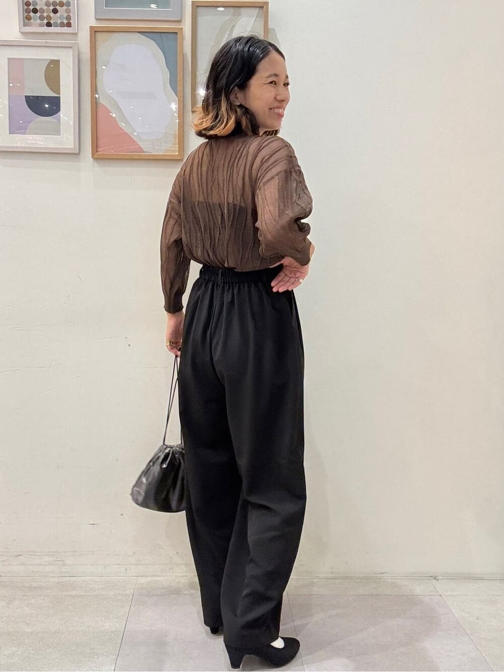 ブラウン系のニット/セーター、ブラック系のその他パンツ、グレー系のショルダーバッグを着用したレディースの秋コーディネートの3枚目の写真