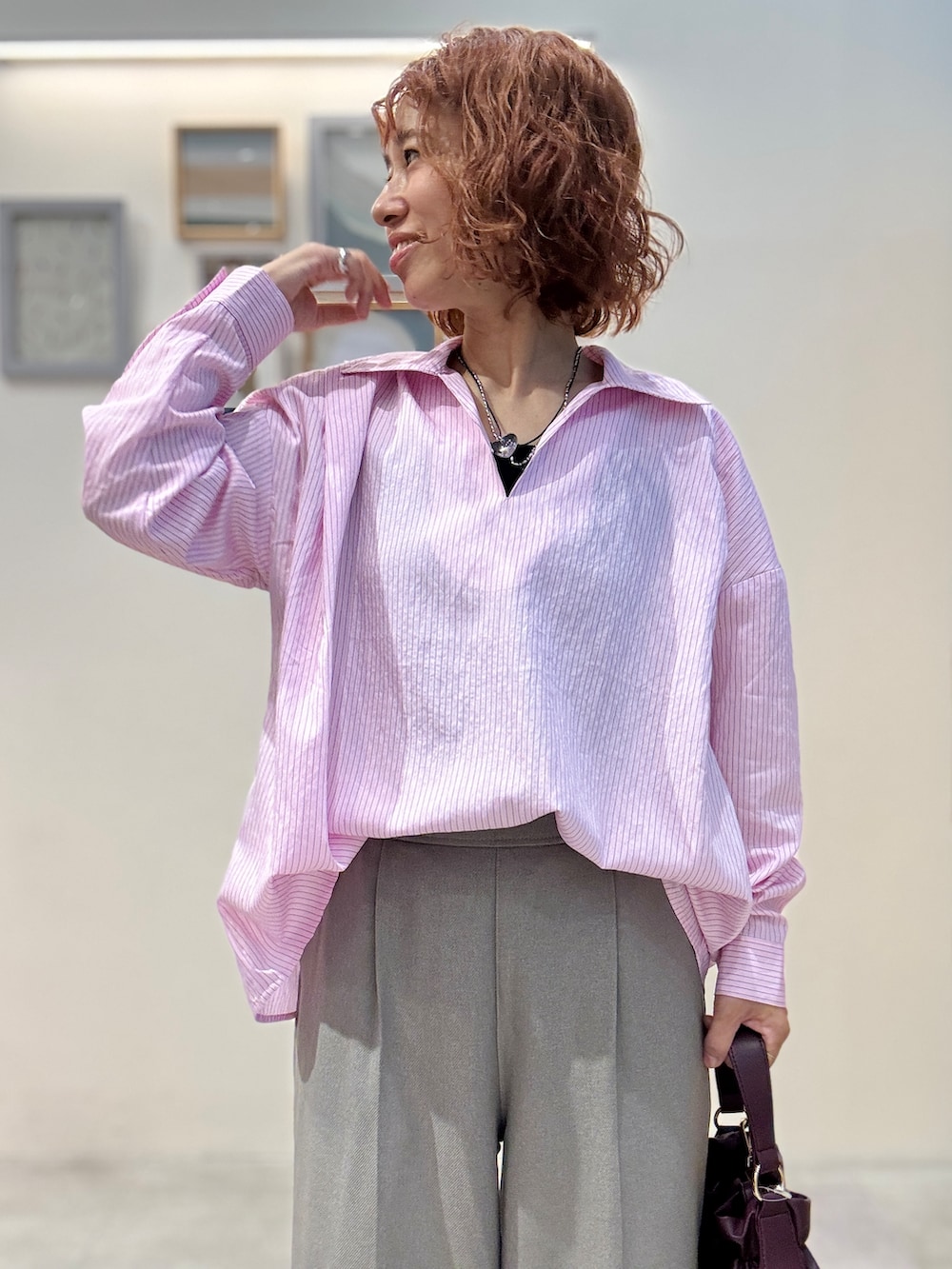ピンク系のシャツ/ブラウス、ベージュ系のその他パンツ、レッド系のショルダーバッグを着用したレディースの秋コーディネートの4枚目の写真