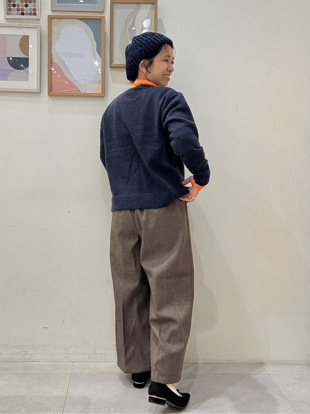 ブルー系のニット/セーター、オレンジ系のTシャツ/カットソー、ベージュ系のその他パンツを着用したレディースの冬コーディネートの3枚目の写真