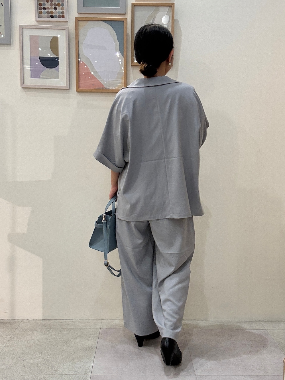 ブラック系のパンプス、ブルー系のシャツ/ブラウス、ブルー系のショルダーバッグを着用したレディースの春コーディネートの3枚目の写真