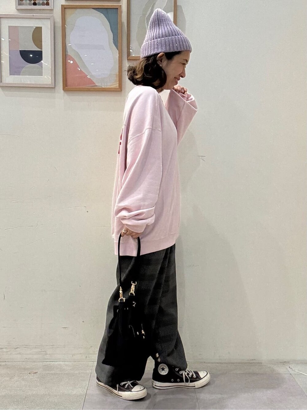 ピンク系のスウェット、グレー系のその他パンツ、ブラック系のショルダーバッグを着用したレディースの秋コーディネートの2枚目の写真