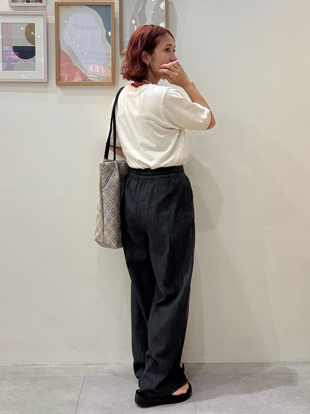 ホワイト系のニット/セーター、ブラック系のデニムパンツ、ベージュ系のトートバッグを着用したレディースの夏コーディネートの3枚目の写真