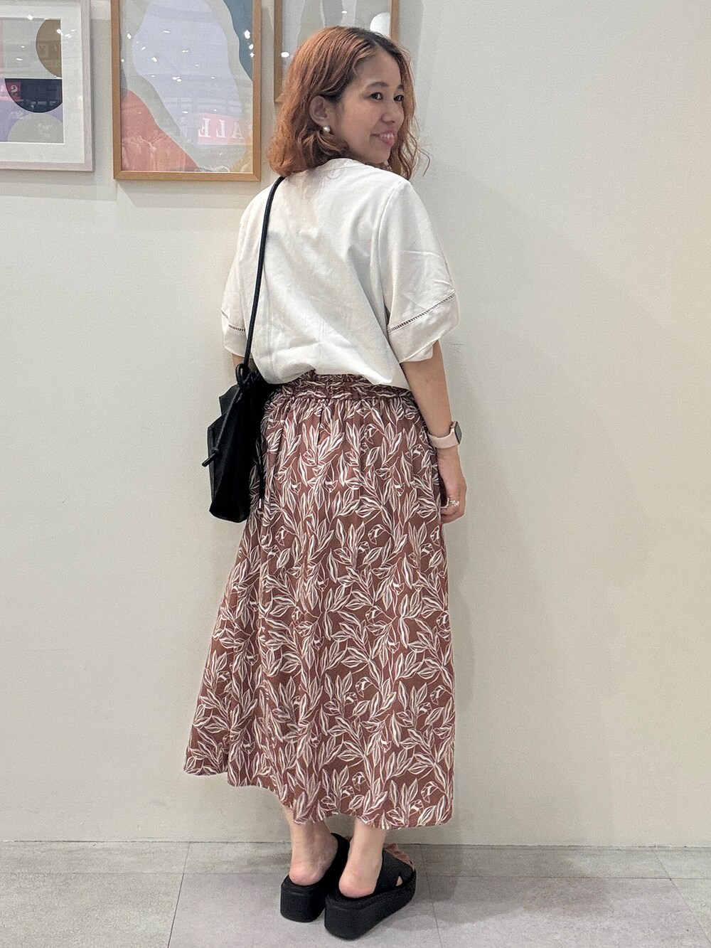 ホワイト系のシャツ/ブラウス、レッド系のスカート、ブラック系のサンダルを着用したレディースの夏コーディネートの3枚目の写真