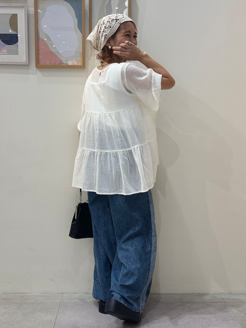 ブルー系のデニムパンツ、ブラック系のサンダルを着用したレディースの夏コーディネートの3枚目の写真