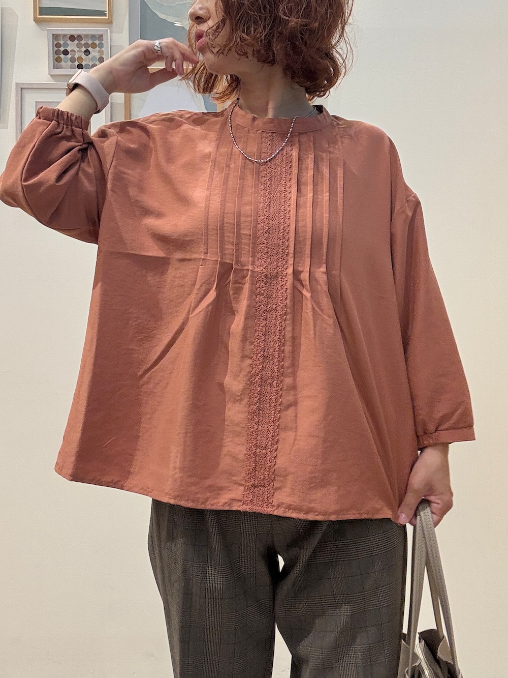 オレンジ系のシャツ/ブラウス、ブラウン系のその他パンツ、ベージュ系のトートバッグを着用したレディースの秋コーディネートの4枚目の写真