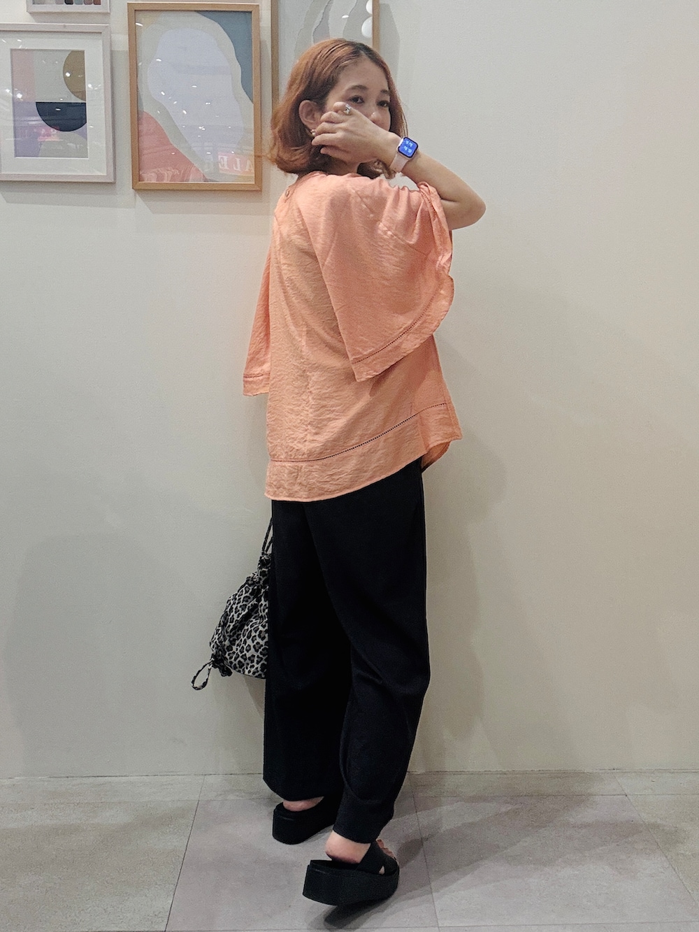 オレンジ系のシャツ/ブラウス、グレー系のその他パンツ、ベージュ系のショルダーバッグを着用したレディースの夏コーディネートの3枚目の写真