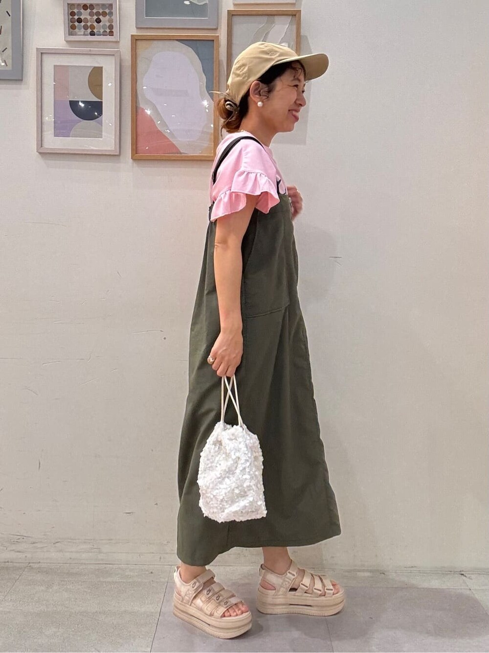 ピンク系のTシャツ/カットソー、グリーン系のワンピース、ホワイト系のショルダーバッグを着用したレディースの夏コーディネートの2枚目の写真