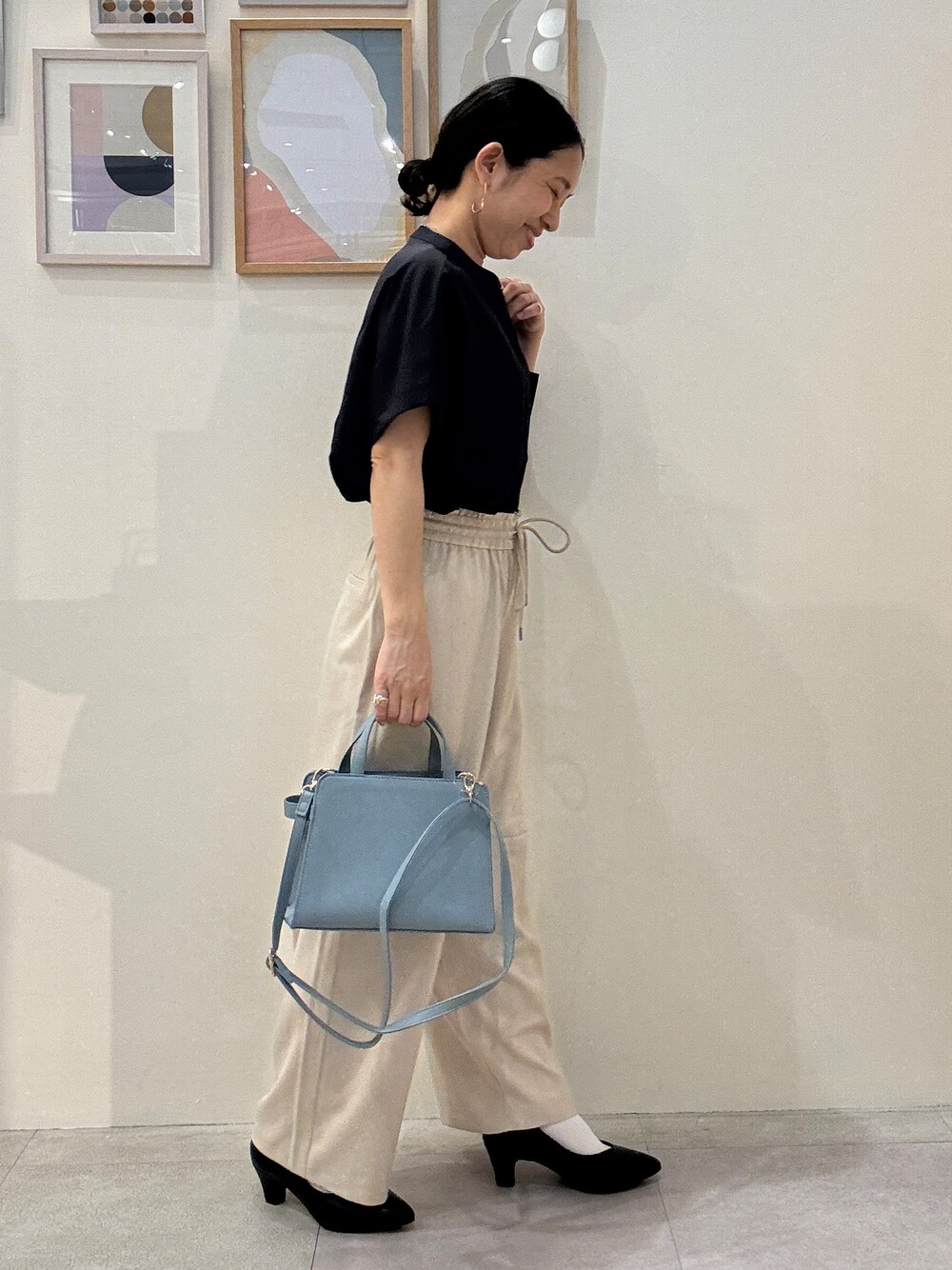 ブラック系のパンプス、ブルー系のショルダーバッグ、ベージュ系のその他パンツを着用したレディースの春コーディネートの2枚目の写真
