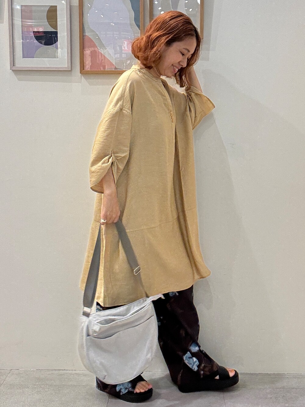イエロー系のワンピース、ブラウン系のその他パンツ、グレー系のショルダーバッグを着用したレディースの夏コーディネートの2枚目の写真