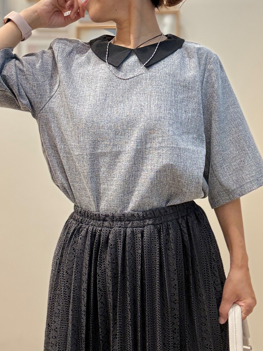 グレー系のシャツ/ブラウス、ブラック系のスカート、ホワイト系のショルダーバッグを着用したレディースの夏コーディネートの5枚目の写真