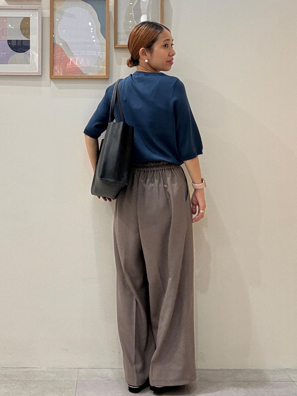 ブルー系のニット/セーター、ブラウン系のその他パンツ、ブラック系のトートバッグを着用したレディースの夏コーディネートの3枚目の写真