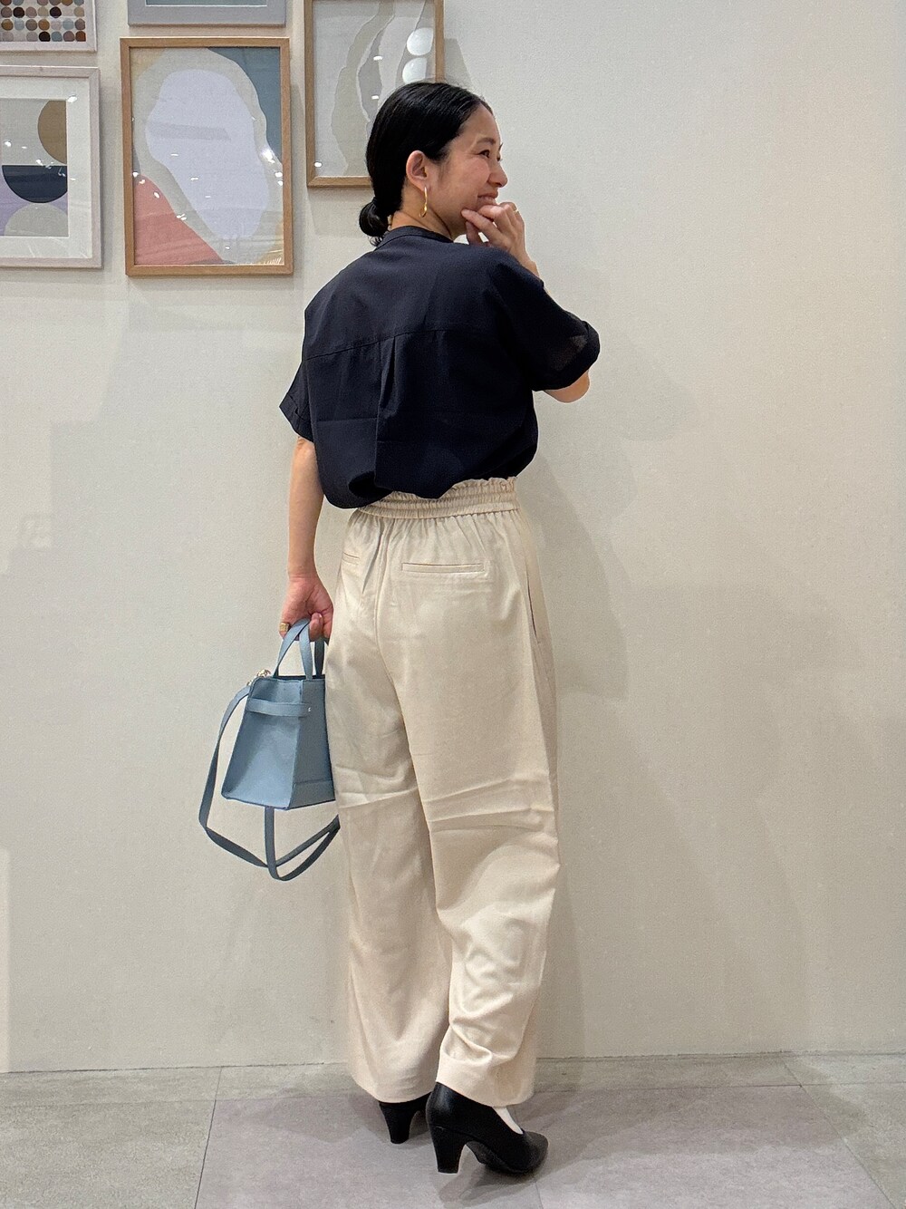 ブラック系のパンプス、ブルー系のショルダーバッグ、ベージュ系のその他パンツを着用したレディースの春コーディネートの3枚目の写真