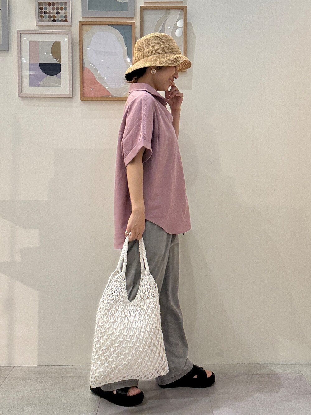 ピンク系のシャツ/ブラウス、グレー系のデニムパンツ、ホワイト系のトートバッグを着用したレディースの春コーディネートの2枚目の写真
