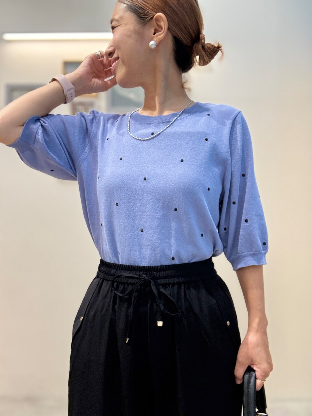 ブルー系のニット/セーター、ブラック系のその他パンツ、ブラック系のショルダーバッグを着用したレディースの夏コーディネートの4枚目の写真