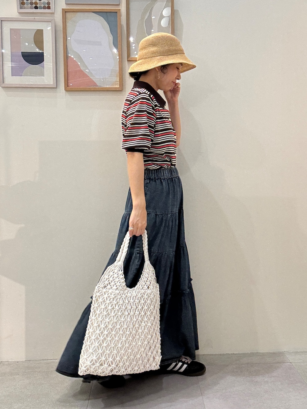 ブラック系のカーゴパンツ、ブルー系のデニムスカート、ホワイト系のトートバッグを着用したレディースの春コーディネートの2枚目の写真