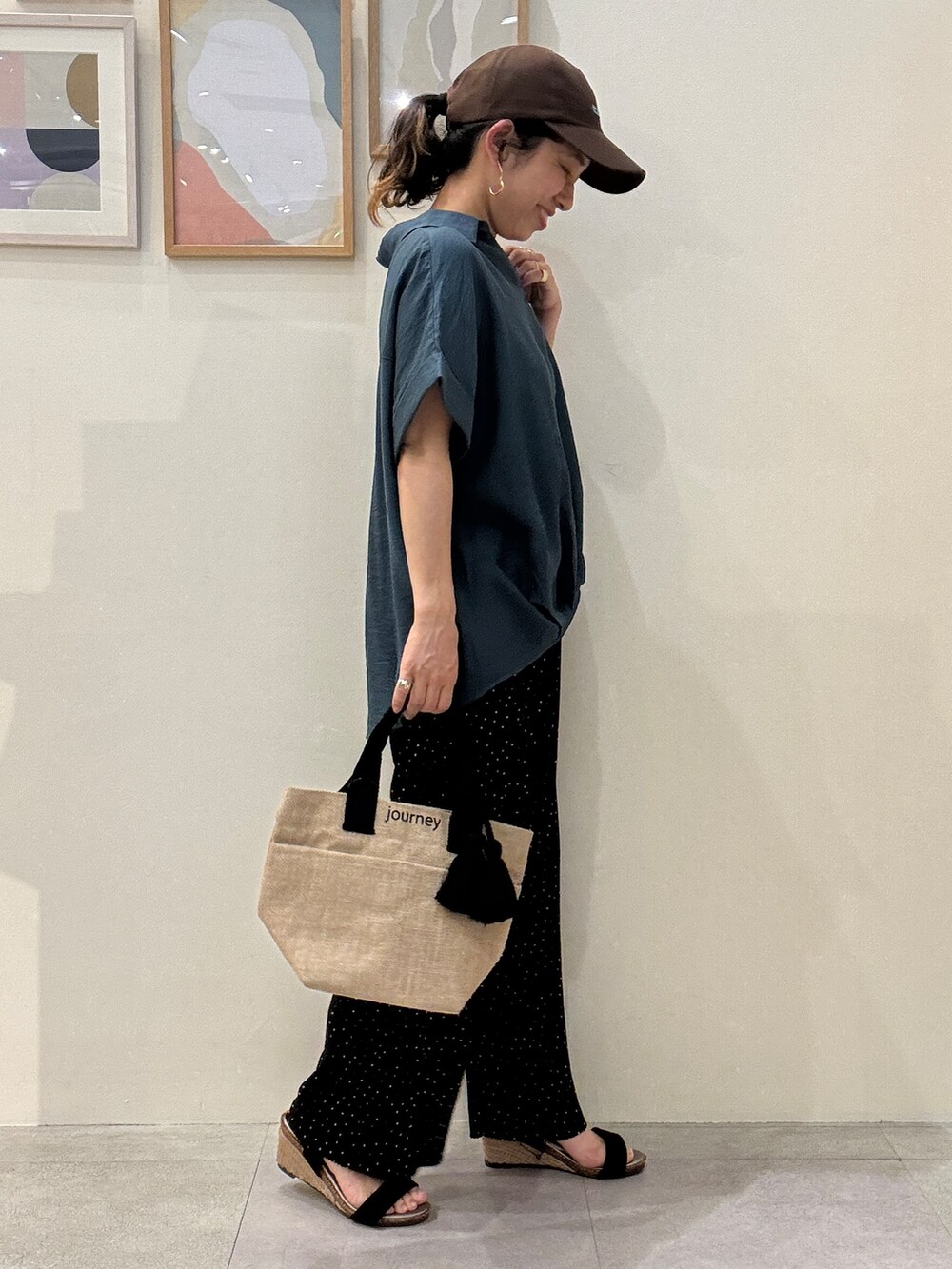 ブラック系のトートバッグ、ブルー系のシャツ/ブラウス、ブラック系のサンダルを着用したレディースの春コーディネートの2枚目の写真