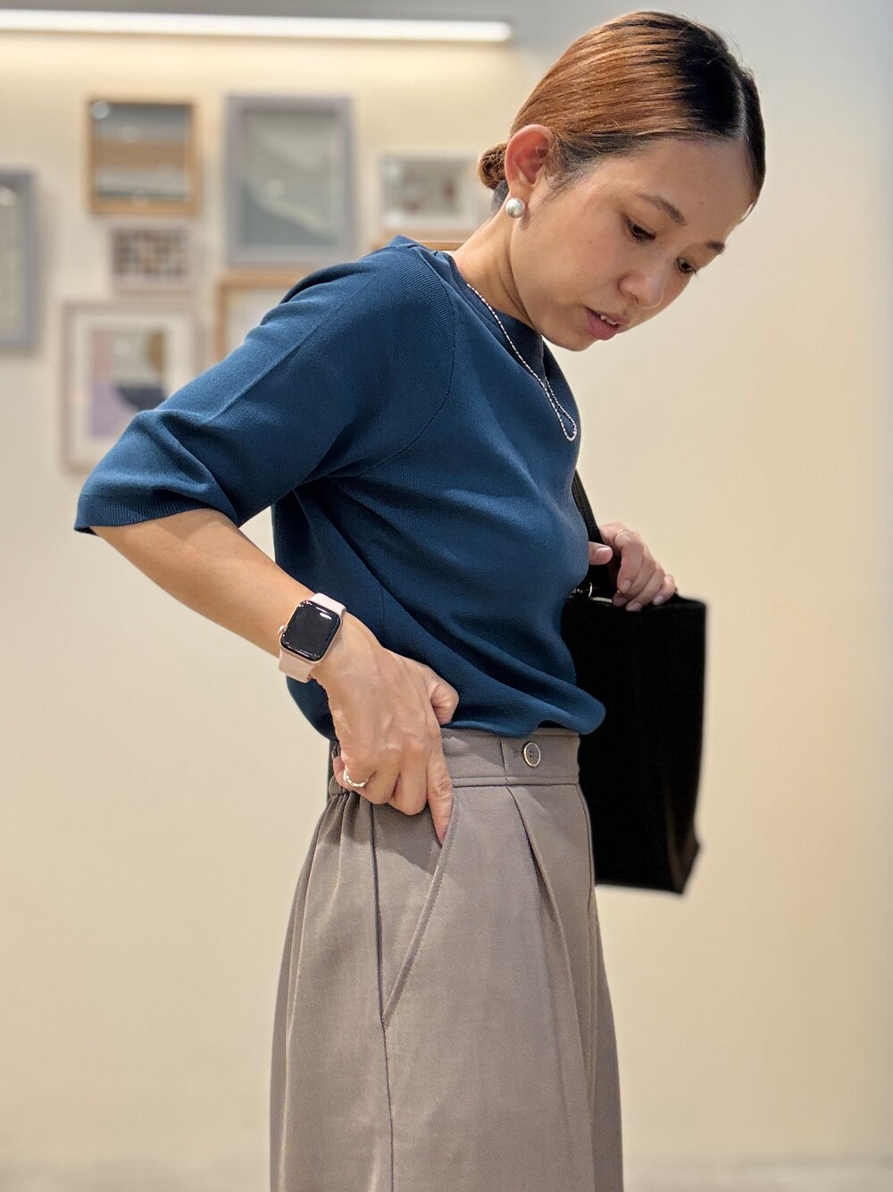 ブルー系のニット/セーター、ブラウン系のその他パンツ、ブラック系のトートバッグを着用したレディースの夏コーディネートの5枚目の写真