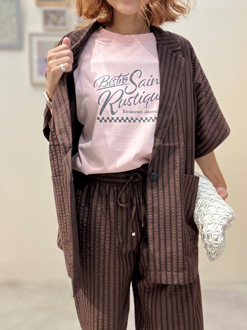ブラウン系のテーラードジャケット、ピンク系のTシャツ/カットソー、ブラウン系のその他パンツを着用したレディースの夏コーディネートの5枚目の写真