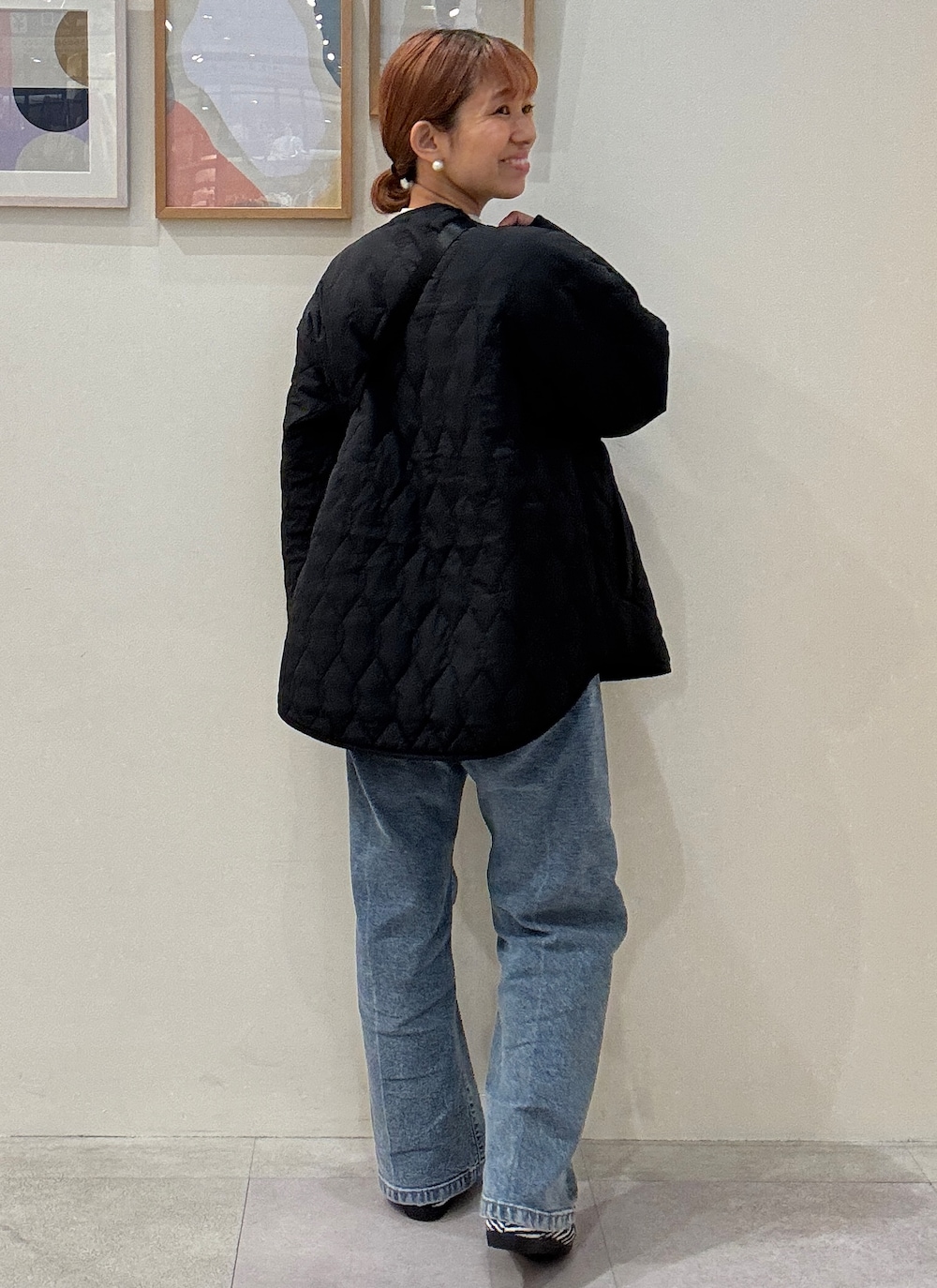 シルバー系のニット/セーター、ブルー系のデニムパンツ、ブラック系のパンプスを着用したレディースの秋コーディネートの3枚目の写真