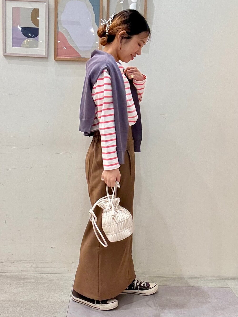 グレー系のカーディガン/ボレロ、ピンク系のTシャツ/カットソー、ブラウン系のスカートを着用したレディースの春コーディネートの2枚目の写真