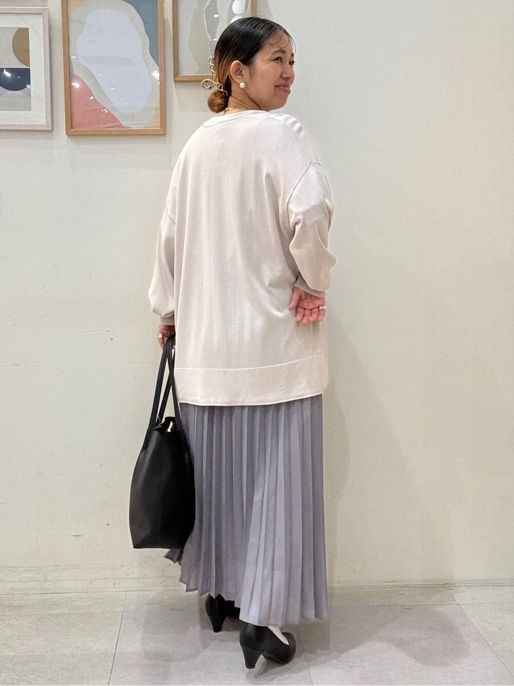 ベージュ系のカーディガン/ボレロ、パープル系のTシャツ/カットソー、グレー系のスカートを着用したレディースの春コーディネートの3枚目の写真